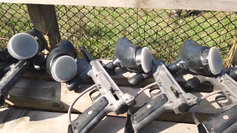 Prepared-for-outdoor-play,-black-paintball-weapons-placed-on-a-wooden-bench