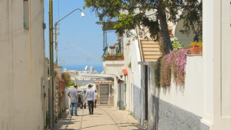 Shot-of-locals-walking-along-an-old-Anacapri-street-in-Capri,-Italy-on-a-sunny-day