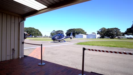 Blauer-Hubschrauber,-Der-Sich-Vom-Hangar-Aus-Auf-Den-Start-Vorbereitet