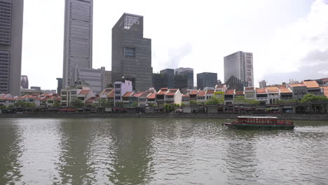Ein-Vollständiger-Blick-Auf-Den-Singapur-Fluss-Mit-Blick-Auf-Die-Pubs,-Bars-Und-Restaurants-Am-Bootskai-Am-Flussufer-Mit-Touristenbooten,-Die-Am-Blauen-Nachmittagshimmel-Vorbeifahren