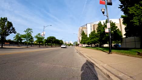 hyper-lapse-point-of-view-of-a-bike-ride-along-a-green-bike-path-in-the-city-metro-area-during-a-sunny-day