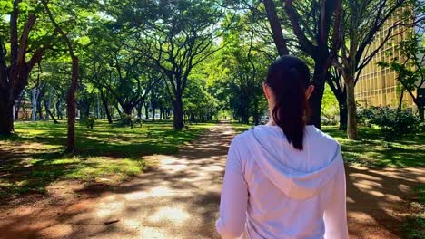 Caucasian-brunette-woman-jogging-in-slow-motion-in-green-park