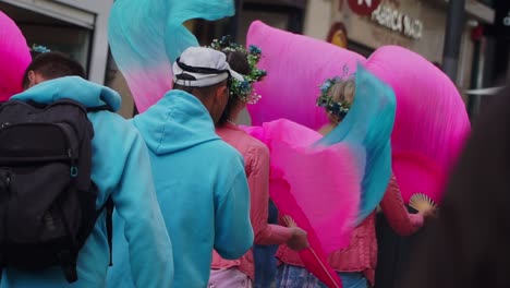 Medium-Focus-Shot,-Group-of-Performers-Walking-on-the-Streets-of-Porto,-Women’s-dress-in-Pink-Holding-and-Waving-a-Folding-Fan