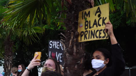 Eine-Schöne-Junge-Frau-Hält-Während-Einer-Protestaktion-Gegen-Rassismus-In-Europa-Ein-Gelbes-Papierschild-In-Der-Hand