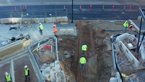Low,-tracking-overhead-shot-of-construction-workers-walking-on-a-commercial-jobsite