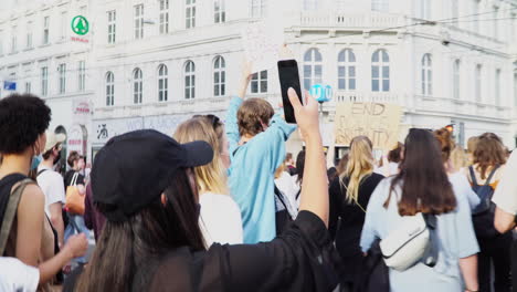 A-young-and-beautiful-woman-is-filming-the-black-lives-matter-protest-in-Vienna-with-her-smartphone