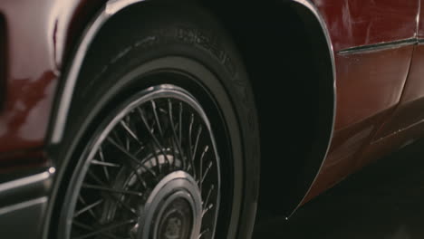 Close-view-of-the-tires-and-the-logo-of-a-red-Cadillac-DeVille-from-the-60s