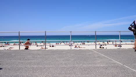 People-walking-in-front-of-sunny-Sydney-Bondi-beach