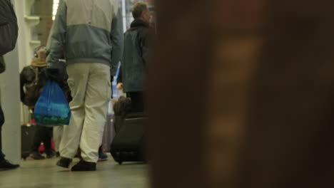Statische-Aufnahme-Von-Passagieren,-Die-Ihr-Gepäck-In-Einem-Sehr-Belebten-Internationalen-Bahnhof-St.-Pancras-In-London-An-Der-Kamera-Vorbeischleppen