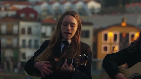 Toma-Panorámica-De-Cerca,-Grupo-De-Mujeres-Jóvenes-Tocando-Sus-Instrumentos-Y-Cantando-En-Porto,-Portugal