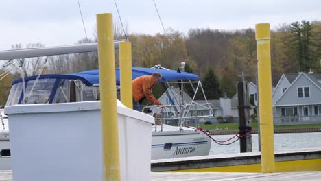 Adult-Male-On-Boat-Lifting-Up-Rope-At-Marina-In-Lake-Michigan