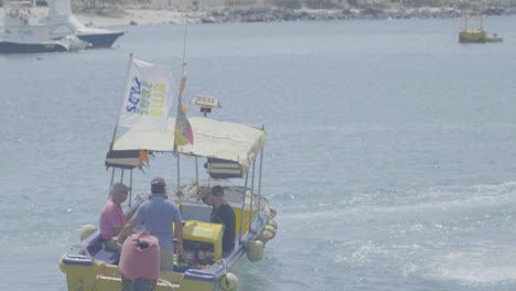 Drei-Touristen-Sind-An-Bord-Eines-Gelben-Bootes,-Das-Sie-Zu-Ihrem-Kreuzfahrtschiff-Auf-Den-Galapagosinseln-In-Ecuador-Bringt