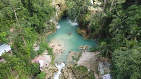 Tourists-swim-in-clear-blue-pool-at-bottom-of-scenic-Kawasan-falls,-Cebu