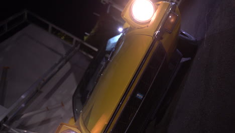 Gelber-Lamborghini-Mit-Aufklappbaren-Scheinwerfern,-Blinkenden-Lichtern-Im-Hintergrund,-Rotierender-Kamerabewegung