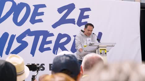 Tom-Van-Grieken,-leader-of-the-Flemish-far-right-political-party-Vlaams-Belang,-speeching-during-protest-meeting-in-Brussels,-Belgium---Medium-shot