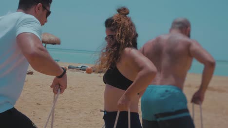 Athletes-racing-walking-using-a-wooden-bar-challenge-by-the-beach---Slow-Motion