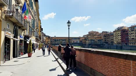 Couples-on-a-romantic-walk-on-the-Amo-river-walkway-on-a-sunny-day,-Florence,-Italy