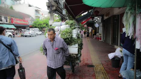 Hombre-Tirando-De-Una-Cesta-Vacía-En-Las-Calles-De-Bangkok-En-El-Mercado-De-Flores