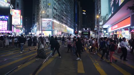 Double-Decker-Bus-Stopped-As-People-Cross-On-The-Pedestrian-Lane-In-Hong-Kong-At-Night---Wide-Shot