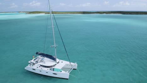 Catamarán-En-Barco-Turístico-De-Bahamas-En-Aguas-Tropicales-Del-Océano-Azul,-Drone-Aéreo