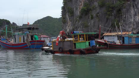 Kleines-Vietnamesisches-Fischerboot,-Das-Langsam-Zwischen-Kalksteinfelsen-Der-Halong-Bucht-Fährt