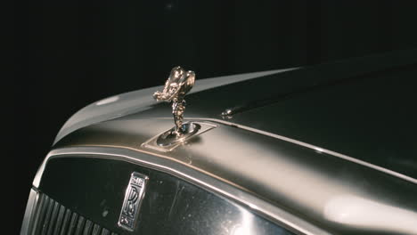 Spirit-of-Ecstasy-hood-ornament-coming-out-from-cover-on-front-bumper-of-Rolls-Royce-car