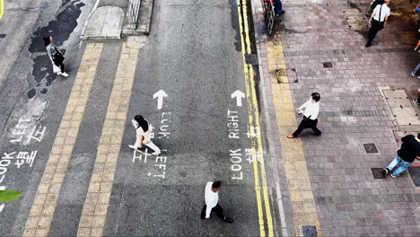 Von-Oben-Nach-Unten-Aufnahme-Von-Menschen-Aus-Hongkong,-Die-Gesichtsmasken-Tragen-Und-Eine-Kleine-Straße-überqueren