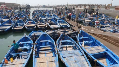 Wide-shot-of-blue-boats-docked-for-the-day-in-harbor