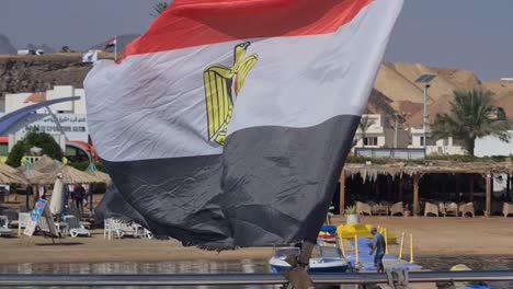 Boot-Verlässt-Den-Hafen-Und-Nahaufnahme-Der-ägyptischen-Flagge,-Die-Im-Wind-Weht