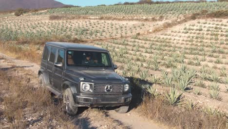 Class-G-Mercedes-Benz-car-driving-a-dirty-road-in-a-desert-landscape
