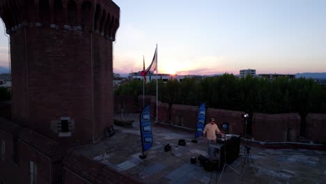 DJ-mixing-atop-Le-Castillet-during-sunset-in-France