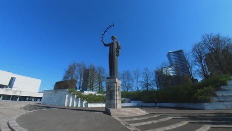 Toma-En-Cámara-Lenta-De-Una-Mujer-Estatua-Con-Pajaritos-En-El-Parque-Vilnius-Sakura
