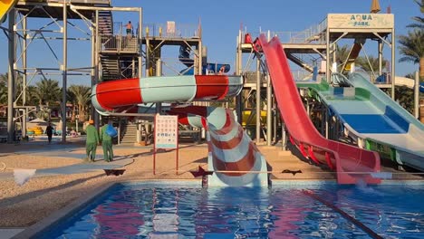 pan-shot-of-aqua-park-with-water-slides-and-two-maintenance-guys-walking-off