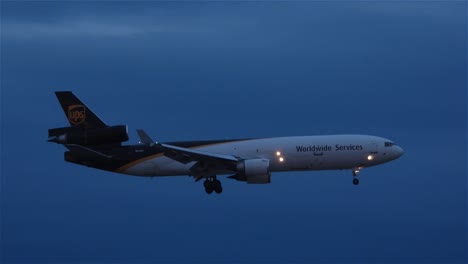 UPS-worldwide-service-airplane-flying-at-blue-hour-dusk-preparing-to-land-at-airport