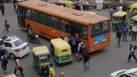 People-get-on-bus-in-busy-traffic,-Delhi-India