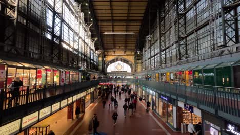 Innenansicht-Der-Beeindruckenden-Halle-Am-Hamburger-Hauptbahnhof-Mit-Geschäften-Und-Vorbeigehenden-Reisenden