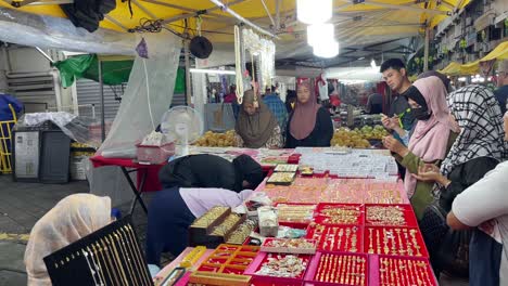 Array-of-jewellery-displayed-neatly-and-a-crowd-of-people-having-good-bargains-with-the-Jeweler-at-the-local-Pasar-Malam-in-Jalan-Tuanku-Abdul-Rahman,-Kuala-Lumpur,-Malaysia