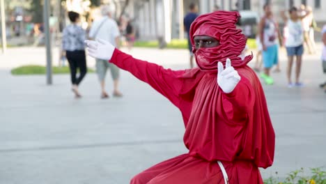 Street-performer,-statue,-dressed-in-red-at-Praca-Maua,-in-the-center-of-Rio-de-Janeiro,-Brazil,-on-a-Sunday-afternoon