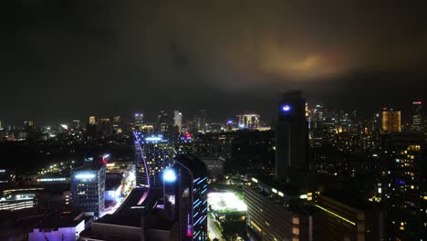 Zeitrafferaufnahme-Des-Nächtlichen-Stadtzentrums-Von-Singapur-Mit-Vorbeiziehenden-Wolken