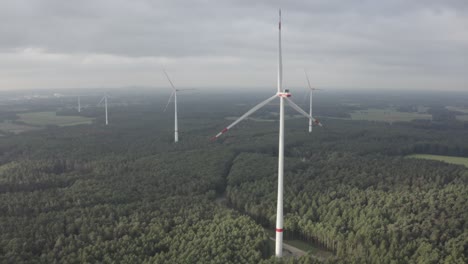 An-approach-drone-shot-of-wind-turbines-in-the-landscape