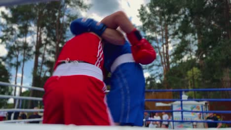Two-boxers-in-the-boxing-ring-fighting,-the-Referee-standing-alongside-fighters,-a-Cinematic-shot