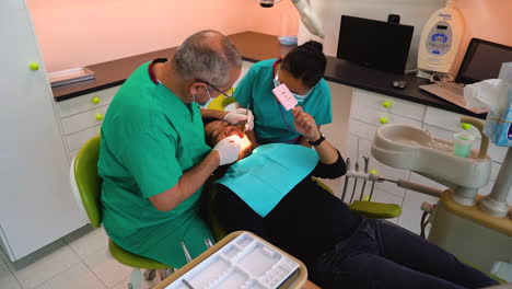 Zeitlupenaufnahme-Eines-Zahnarztes-Und-Einer-Krankenschwester,-Die-Eine-Zahnärztliche-Untersuchung-An-Einem-Patienten-Durchführen
