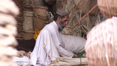 Dolly-Rechts-Zeigt-Einen-älteren-Pakistanischen-Mann,-Der-Durch-Weben-Einen-Korb-Herstellt