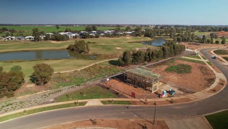 Yarrawonga,-Victoria,-Australia---14-May-2023:-Aerial-around-two-storey-house-under-construction-with-golf-course-in-background-at-Silverwoods-Estate-in-Yarrawonga-Victoria