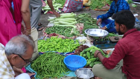 Unidentified-woman-sells-fruits-in-a-crowded-market,-young-parson-buying-vegetables-close-up-shoot