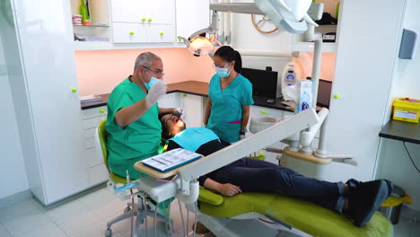 Handaufnahme-Eines-Zahnarztes,-Der-Das-Licht-So-Anordnet,-Dass-Er-Den-Besten-Blick-In-Den-Mund-Seines-Patienten-Erhält