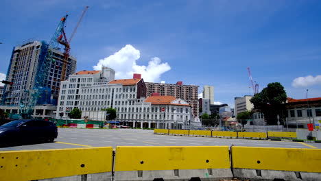 Ciudad-De-Singapur-Con-Ampliación-De-Carreteras-Y-Construcción-De-Edificios,-Desarrollo-De-Viviendas,-Vehículos-Circulando-Por-La-Carretera-Bajo-El-Soleado-Fondo-Del-Cielo-Azul