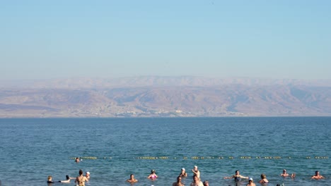 Gruppe-Von-Menschen,-Die-Auf-Dem-Wasser-Im-Toten-Meer-In-Israel-Schwimmen