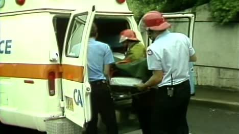 Paramédicos-Cargando-A-La-Víctima-En-La-Parte-Trasera-De-Una-Ambulancia-De-La-Década-De-1980