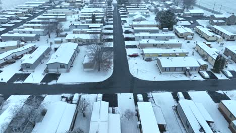 Snowy-suburban-trailer-park-neighborhood-with-winding-road-and-modular-houses